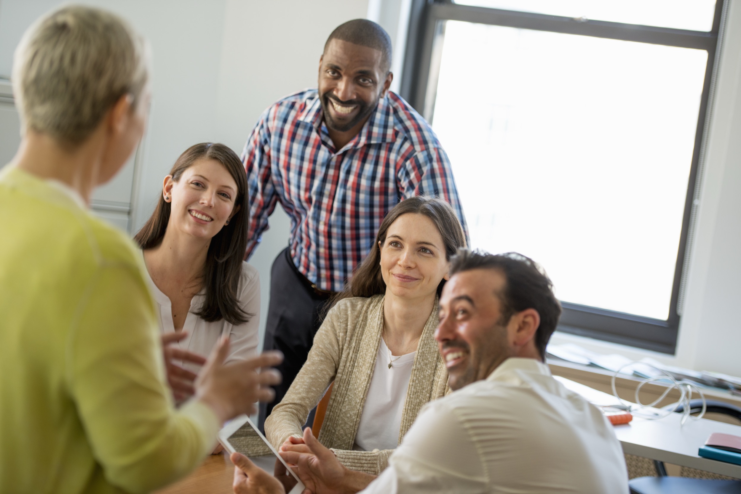 New York City,USA,Five people in an office, two men and three women talking.